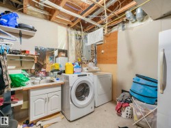 Laundry room with independent washer and dryer, electric panel, and concrete flooring - 