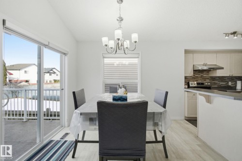 Dining room featuring light wood-style floors, a chandelier, and lofted ceiling - 3248 22 Street, Edmonton, AB - Indoor Photo Showing Dining Room