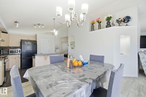 Dining room featuring light wood-type flooring, vaulted ceiling, and hanging lights - 3248 22 Street, Edmonton, AB - Indoor Photo Showing Other Room