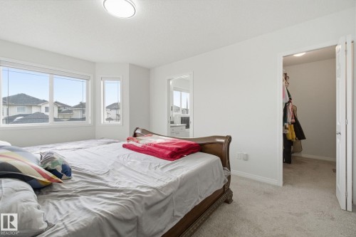 Bedroom featuring a spacious closet and carpet flooring - 3248 22 Street, Edmonton, AB - Indoor Photo Showing Bedroom