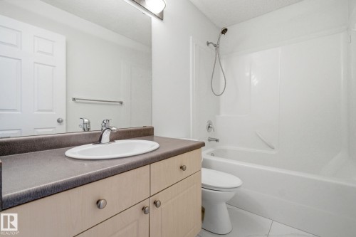 Full bathroom with vanity, bathtub / shower combination, and a textured ceiling - 3248 22 Street, Edmonton, AB - Indoor Photo Showing Bathroom