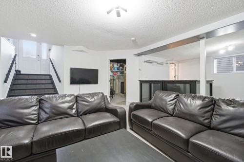 Living room featuring stairway and a textured ceiling - 3248 22 Street, Edmonton, AB - Indoor Photo Showing Other Room