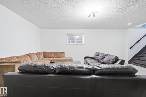 Living room with a textured ceiling and stairs - 3248 22 Street, Edmonton, AB - Indoor Photo Showing Living Room