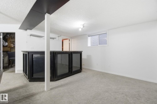 Below grade area with light colored carpet and a textured ceiling - 3248 22 Street, Edmonton, AB - Indoor