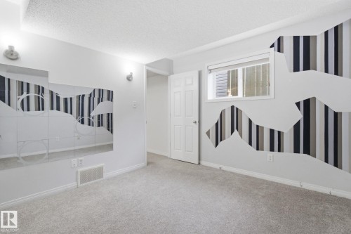 Spare room with a textured ceiling, carpet flooring, and wallpapered walls - 3248 22 Street, Edmonton, AB - Indoor Photo Showing Other Room