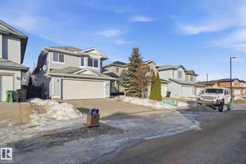 View of front of house featuring concrete driveway, a residential view, and an attached garage - 3248 22 Street, Edmonton, AB - Outdoor