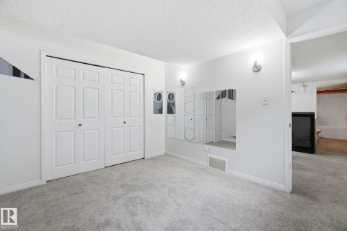 Unfurnished bedroom with carpet flooring, a textured ceiling, and a closet - 3248 22 Street, Edmonton, AB - Indoor Photo Showing Other Room