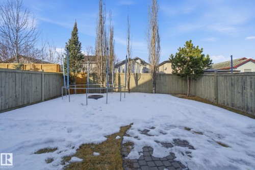 Yard layered in snow featuring a fenced backyard, a trampoline, and a residential view - 3248 22 Street, Edmonton, AB - Outdoor