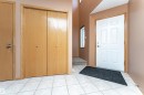 Foyer entrance featuring light tile patterned floors and a textured ceiling - 24 211 Blackburn Drive E, Edmonton, AB  - Indoor Photo Showing Other Room 