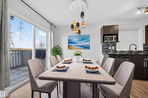 Dining area with light wood-style floors and suspended lighting - 5212 1A Avenue, Edmonton, AB - Indoor Photo Showing Dining Room