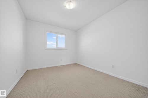 Carpeted spare room with baseboards and vaulted ceiling - 5212 1A Avenue, Edmonton, AB - Indoor Photo Showing Other Room