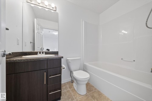 Full bath with vanity, shower / tub combination, and light tile patterned floors - 5212 1A Avenue, Edmonton, AB - Indoor Photo Showing Bathroom