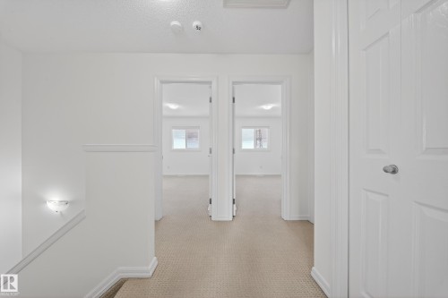 Hallway with light carpet and baseboards - 5212 1A Avenue, Edmonton, AB - Indoor Photo Showing Other Room