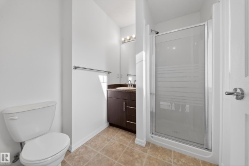 Full bath featuring a shower stall, vanity, and light tile patterned floors - 5212 1A Avenue, Edmonton, AB - Indoor Photo Showing Bathroom