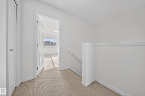 Hall with an upstairs landing and light colored carpet - 5212 1A Avenue, Edmonton, AB - Indoor Photo Showing Other Room