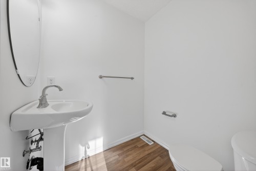 Half bathroom featuring toilet and wood finished floors - 5212 1A Avenue, Edmonton, AB - Indoor Photo Showing Bathroom