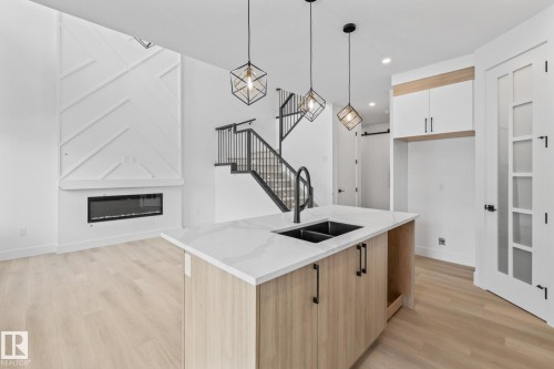 26 Blackbird Bend, Fort Saskatchewan, AB - Indoor Photo Showing Kitchen With Fireplace With Double Sink