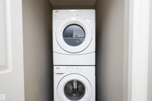 Laundry area with stacked washer and dryer and a textured ceiling - 13 5317 3 Avenue, Edmonton, AB - Indoor Photo Showing Laundry Room
