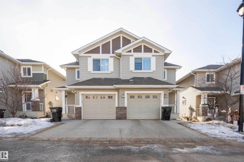 Craftsman-style home with stone siding, driveway, and an attached garage - 13 5317 3 Avenue, Edmonton, AB - Outdoor With Facade