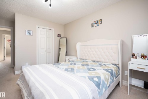 Bedroom with light colored carpet, a textured ceiling, and a closet - 13 5317 3 Avenue, Edmonton, AB - Indoor Photo Showing Bedroom