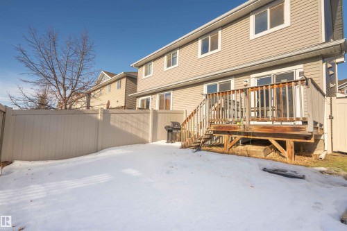 Snow covered back of property with a wooden deck - 13 5317 3 Avenue, Edmonton, AB - Outdoor