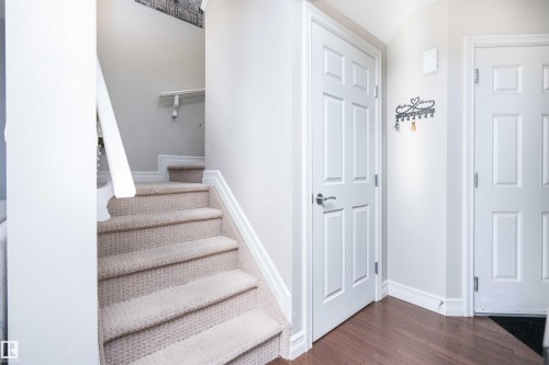 Stairway featuring baseboards and wood finished floors - 13 5317 3 Avenue, Edmonton, AB - Indoor Photo Showing Other Room