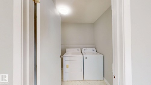 Laundry room with separate washer and dryer and baseboards - 611 2908 116A Avenue, Edmonton, AB - Indoor Photo Showing Laundry Room