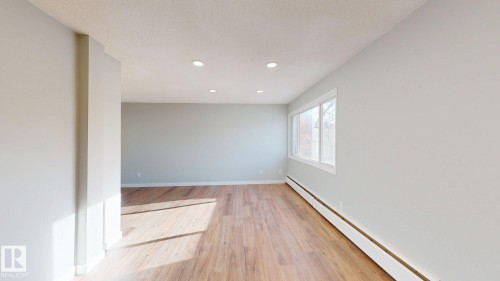 Empty room with a baseboard radiator, light wood finished floors, recessed lighting, and a textured ceiling - 611 2908 116A Avenue, Edmonton, AB - Indoor Photo Showing Other Room