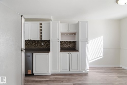 Kitchen featuring dark countertops, backsplash, freestanding refrigerator, and open shelves - 180 Londonderry Square, Edmonton, AB - Indoor Photo Showing Other Room