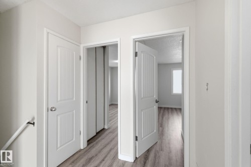 Corridor with a textured ceiling and light wood-type flooring - 180 Londonderry Square, Edmonton, AB - Indoor Photo Showing Other Room