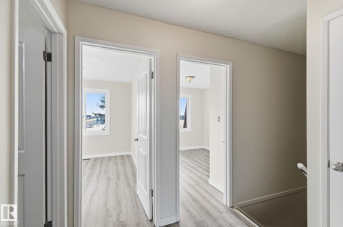 Hall with baseboards and light wood-style flooring - 180 Londonderry Square, Edmonton, AB - Indoor Photo Showing Other Room