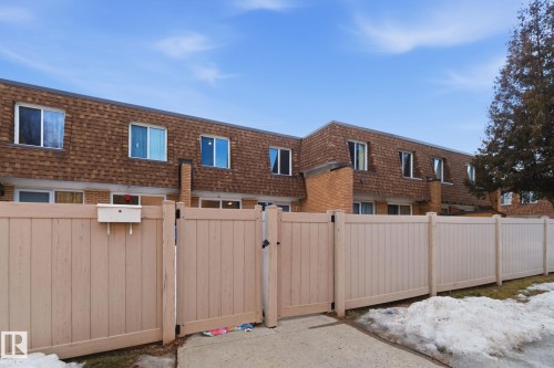 Exterior space with mansard roof, a gate, roof with shingles, and brick siding - 180 Londonderry Square, Edmonton, AB - Outdoor With Exterior