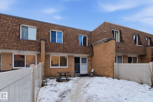 Snow covered back of property featuring mansard roof, brick siding, and roof with shingles - 180 Londonderry Square, Edmonton, AB - Outdoor With Exterior