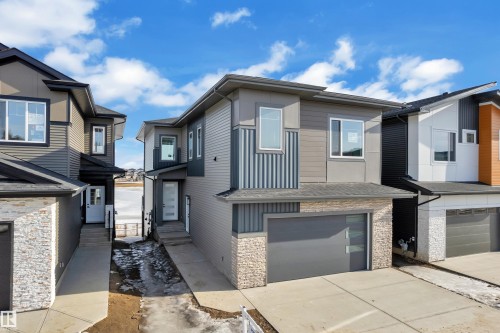 Contemporary house with an attached garage, stone siding, and driveway - 228 Linden Loop, Leduc, AB - Outdoor With Facade