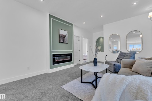 Living room with carpet floors, a glass covered fireplace, and recessed lighting - 228 Linden Loop, Leduc, AB - Indoor Photo Showing Living Room With Fireplace