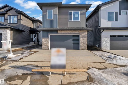 Contemporary home with stone siding, a garage, and driveway - 228 Linden Loop, Leduc, AB - Outdoor With Facade