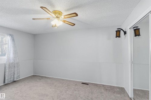 Unfurnished room with light carpet, a textured ceiling, and ceiling fan - 135 Humberstone Road, Edmonton, AB - Indoor Photo Showing Other Room