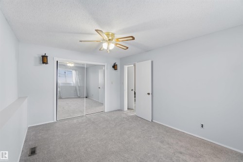 Unfurnished bedroom with carpet flooring, a closet, a textured ceiling, and ceiling fan - 135 Humberstone Road, Edmonton, AB - Indoor Photo Showing Other Room