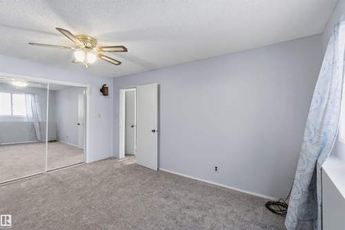 Unfurnished bedroom with carpet flooring, a closet, a ceiling fan, and a textured ceiling - 135 Humberstone Road, Edmonton, AB - Indoor Photo Showing Other Room