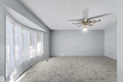Carpeted spare room with a ceiling fan and a textured ceiling - 135 Humberstone Road, Edmonton, AB - Indoor Photo Showing Other Room