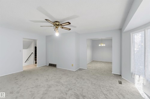 Spare room featuring a ceiling fan, light carpet, and hanging lights - 135 Humberstone Road, Edmonton, AB - Indoor Photo Showing Other Room