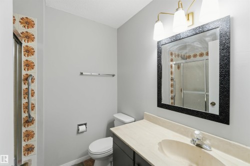 Bathroom with a stall shower, vanity, and a textured ceiling - 135 Humberstone Road, Edmonton, AB - Indoor Photo Showing Bathroom
