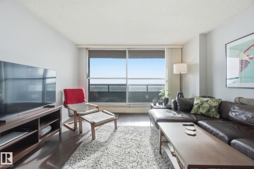 Living area with light wood-style flooring and a textured ceiling - 1312 13910 Stony Plain Road, Edmonton, AB - Indoor Photo Showing Living Room