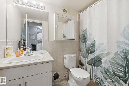Bathroom with vanity, curtained shower, and tile walls - 1312 13910 Stony Plain Road, Edmonton, AB - Indoor Photo Showing Bathroom