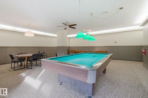 Rec room with a wainscoted wall, billiards table, a decorative wall, a ceiling fan, and a textured ceiling - 1312 13910 Stony Plain Road, Edmonton, AB - Indoor Photo Showing Other Room