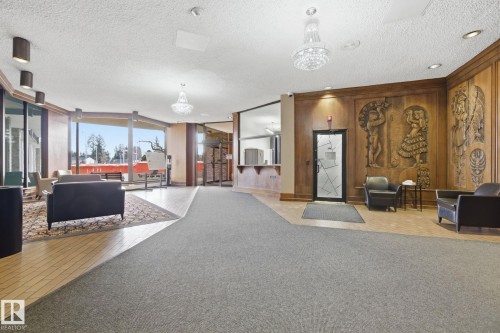 Common area featuring a textured ceiling, expansive windows, and wooden walls - 1312 13910 Stony Plain Road, Edmonton, AB - Indoor Photo Showing Other Room