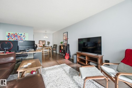 Living room with wood finished floors and hanging lights - 1312 13910 Stony Plain Road, Edmonton, AB - Indoor Photo Showing Living Room