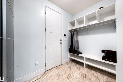 Mudroom featuring a textured ceiling and light marble finish flooring - 4811 Woolsey Lane, Edmonton, AB - Indoor Photo Showing Other Room