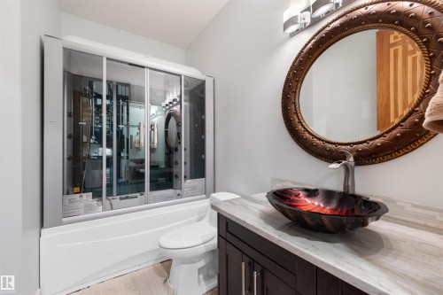 Bathroom featuring vanity, shower / bath combination with glass door, and light wood finished floors - 4811 Woolsey Lane, Edmonton, AB - Indoor Photo Showing Bathroom