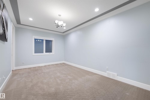 Spare room featuring light carpet and a chandelier - 4811 Woolsey Lane, Edmonton, AB - Indoor Photo Showing Other Room